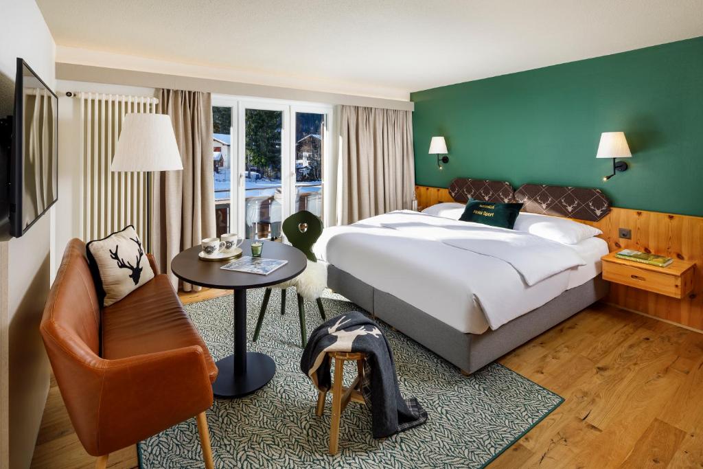Postel nebo postele na pokoji v ubytování Hotel Sport Klosters