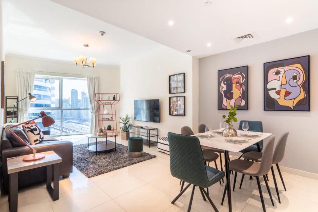 a living room with a table and chairs and a couch at GuestReady - Jumeirah Lakes View in Dubai