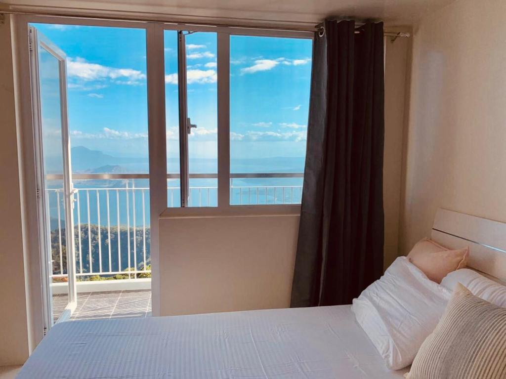 une chambre avec un lit et une grande fenêtre dans l'établissement SMDC Wind Residences Tagaytay by Cris, à Tagaytay