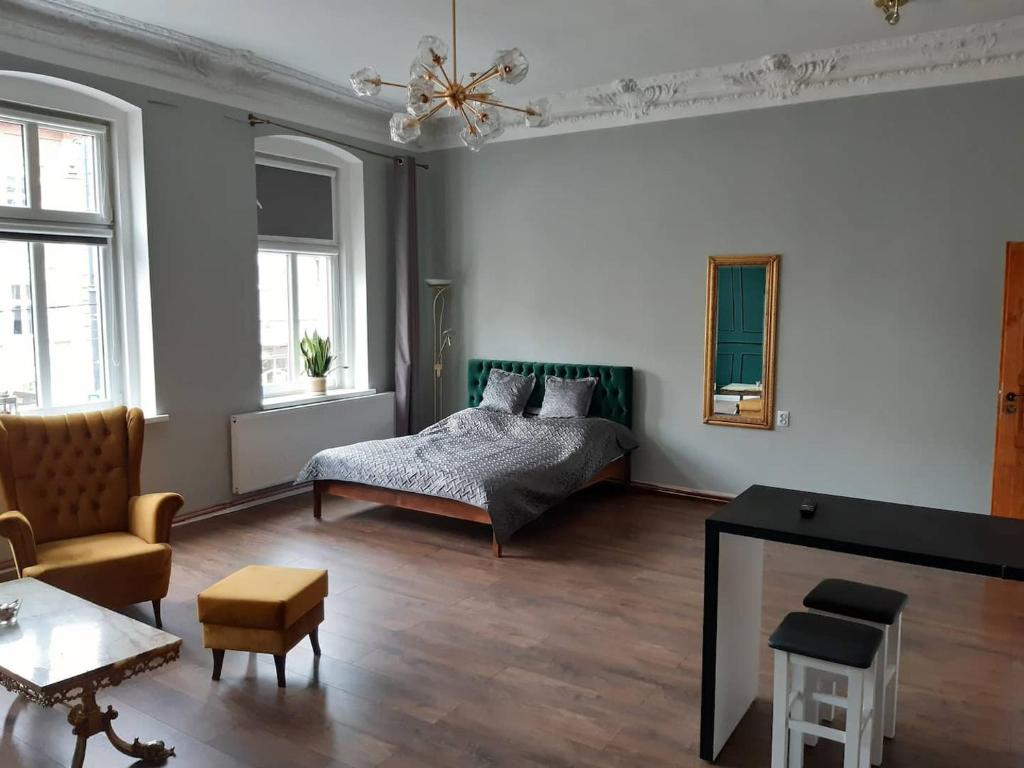 a bedroom with a bed and a living room at Kamienica Bydgoska in Bydgoszcz