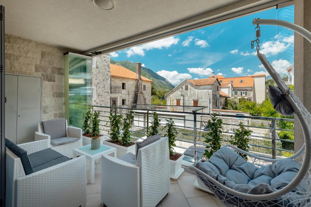 een kamer met een balkon met stoelen en een schommel bij Apartments Dabinovic in Kotor