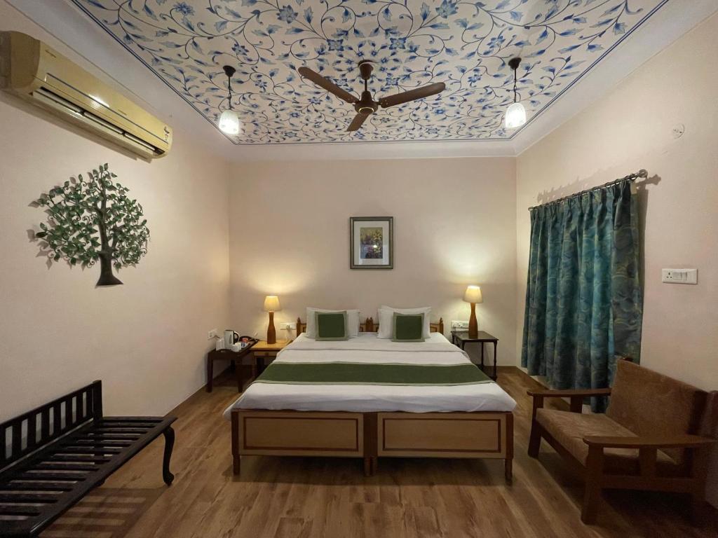 a bedroom with a bed and a ceiling with a ceiling fan at Suryaa Villa - A Boutique Heritage Hotel in Jaipur