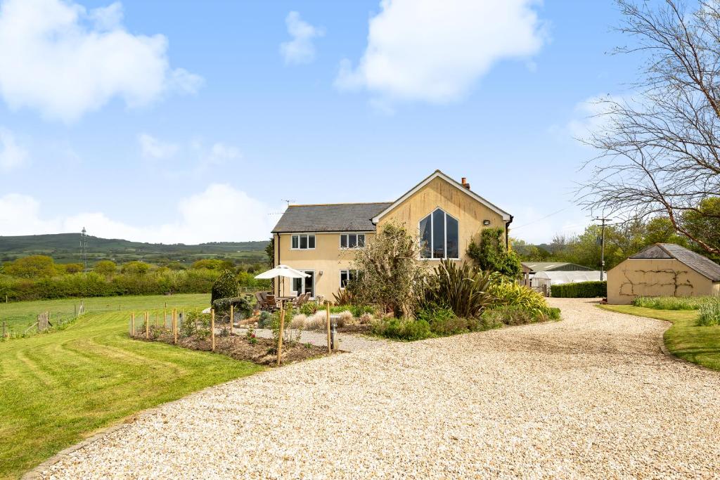 a driveway leading to a house with a garden at Copse Gate Farm in Bridport