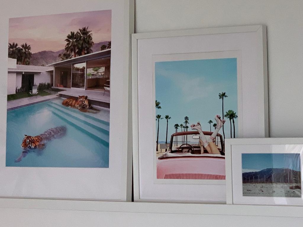 two framed photographs of a swimming pool in a room at Porth Beach Hotel in Newquay