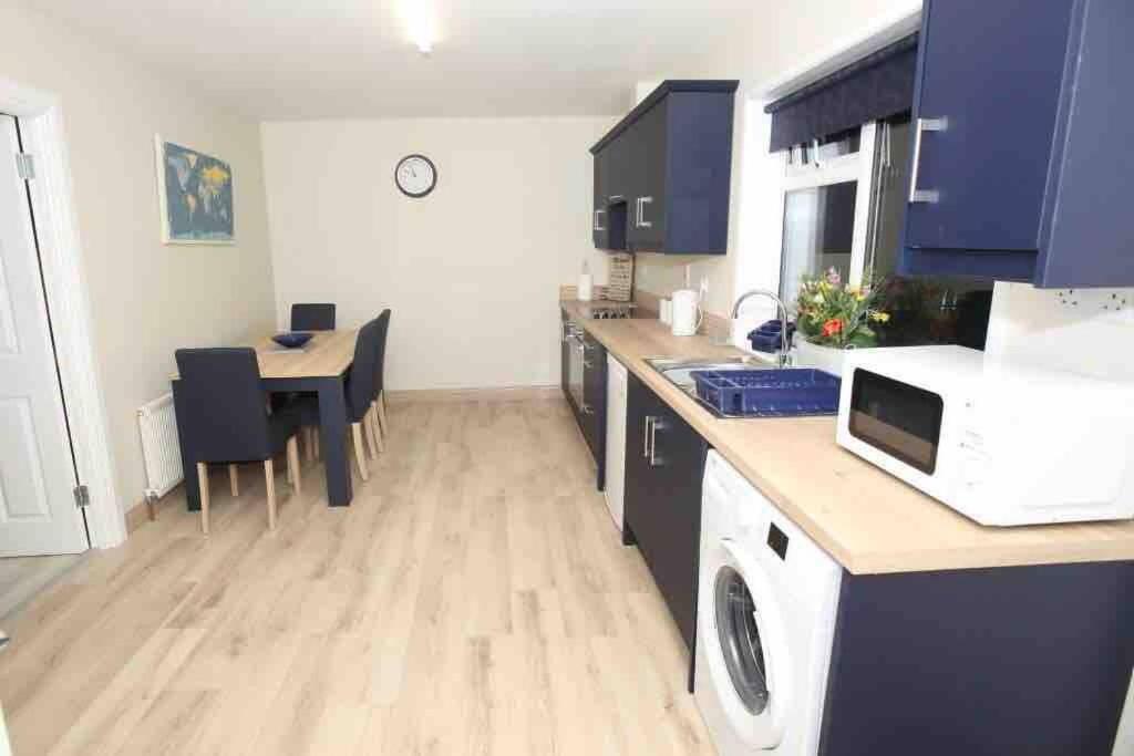 una cucina con tavolo e piano di lavoro di “John Bs” 1 Bedroom Apartment in Ardara a Ardara