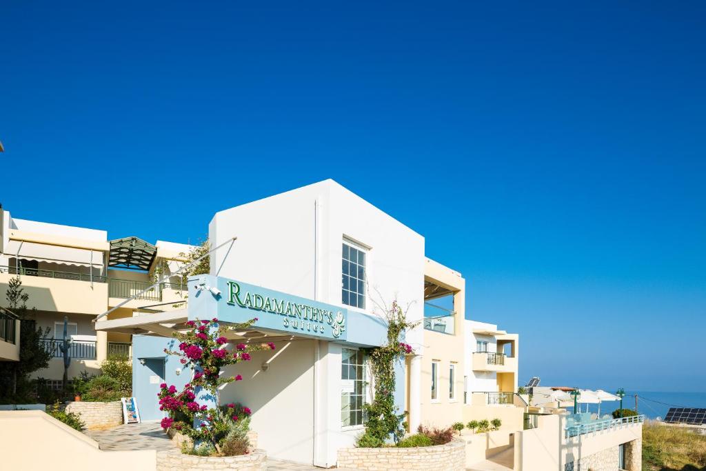 a white building with a sign on it at Radamanthy's Hotel Apartments in Sfakaki