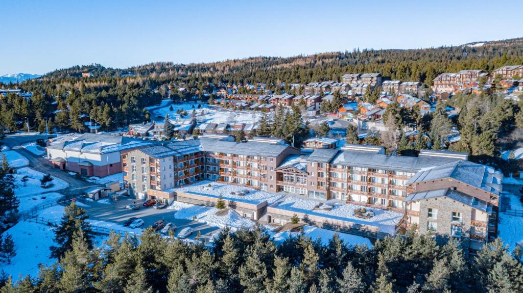 eine Luftansicht eines Resorts im Schnee in der Unterkunft Vacancéole - Appart'Vacances Pyrénées 2000 in Bolquere