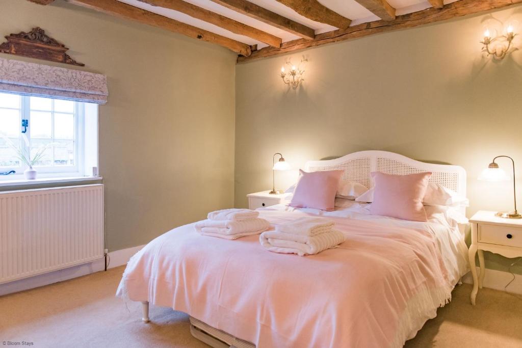 Un dormitorio con una cama blanca con toallas. en Old Post Office sleeps 4 by Bloom Stays, en Faversham