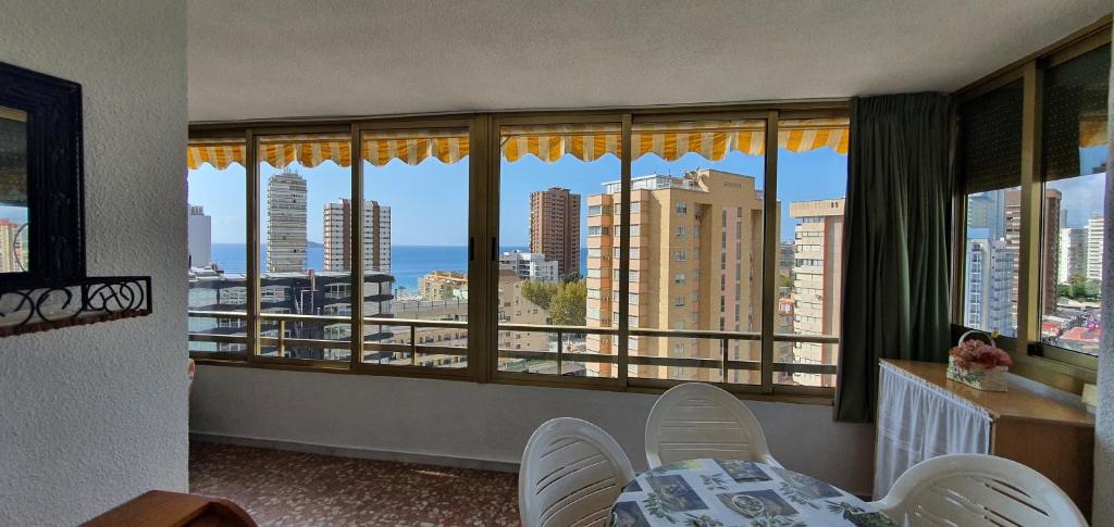 a living room with a view of the ocean from windows at Mariscal I - Fincas Arena in Benidorm