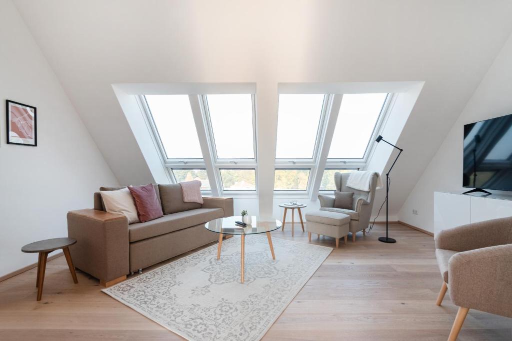 een woonkamer met een bank, 2 stoelen en een tafel bij Sophienne Apartments in Wenen