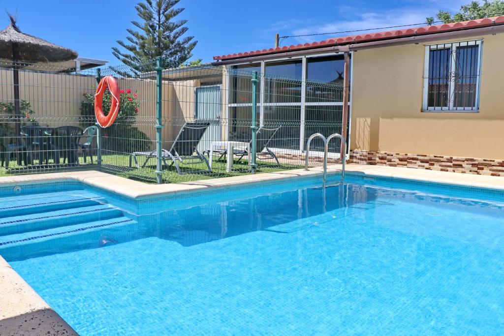 ein Swimmingpool vor einem Haus in der Unterkunft Bungalow Curro Pareja 97 in Conil de la Frontera