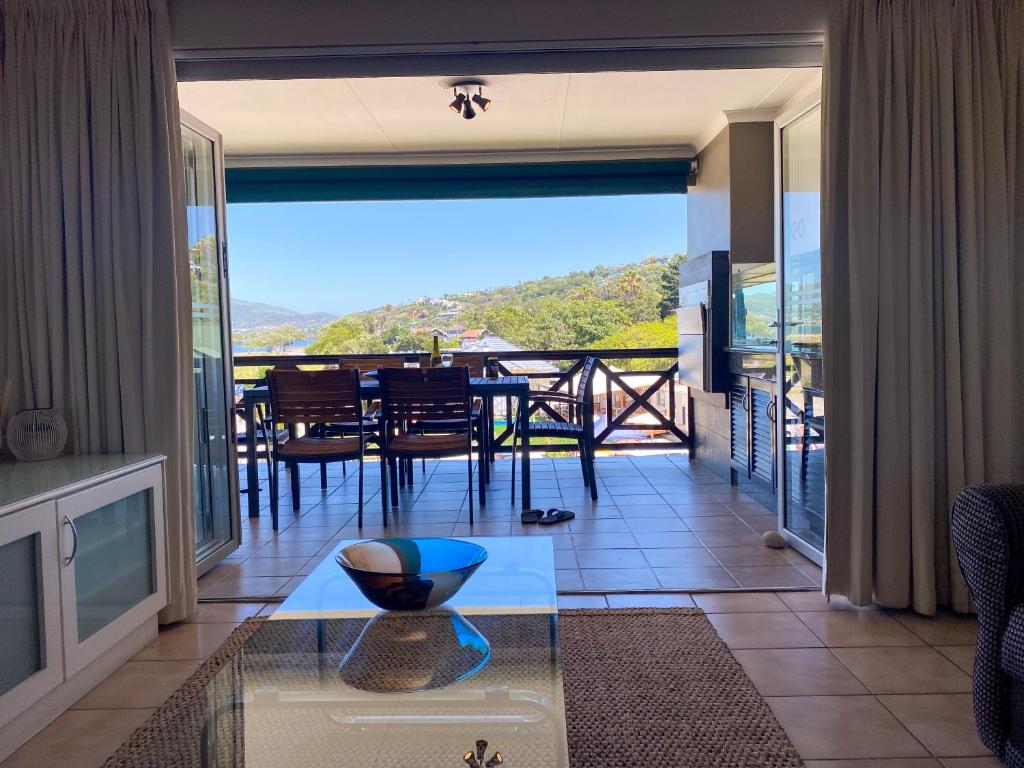 a living room with a glass table and a balcony at 9 Summerplace in Knysna