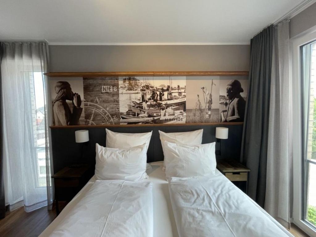um quarto com duas camas e uma foto na parede em 4Hafenzeiten - Ferienwohnung NIE 8 Albatros em Niendorf