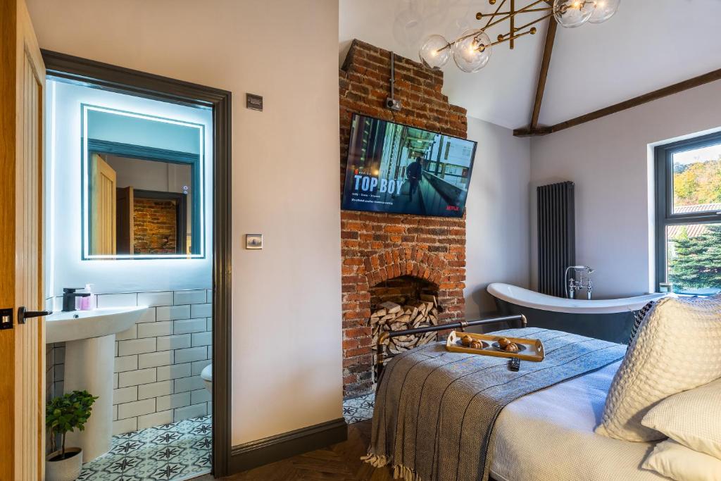 um quarto com lareira e uma cama num quarto em The Secret Cottage - Morpeth em Morpeth