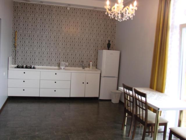a kitchen with a white refrigerator and a table and chairs at Vacation House in Truskavets