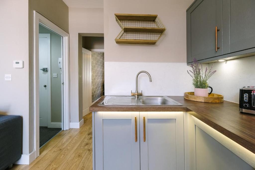 a kitchen with white cabinets and a sink at Old Market Apartments in Bristol