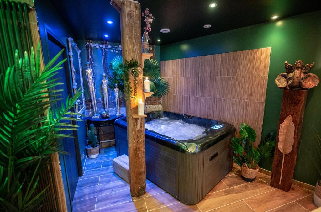 a bathroom with a jacuzzi tub and plants at L'Escapade in Rouen