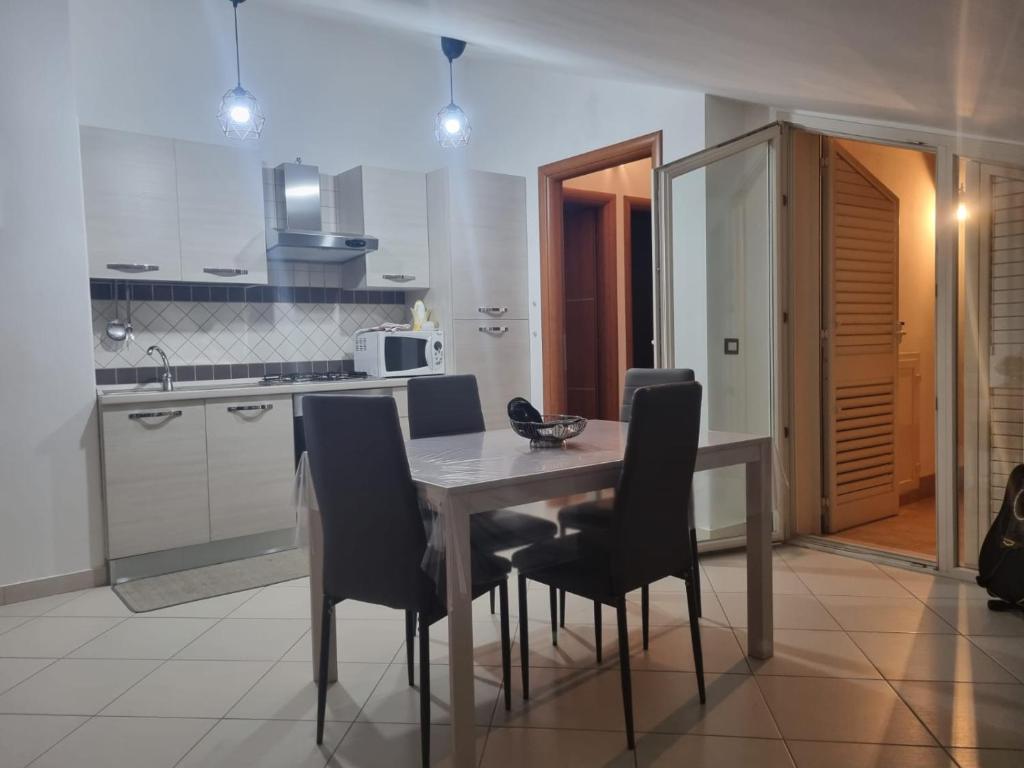 een keuken met een eettafel en stoelen bij Casa vacanze appartamento Policoro ( Matera ) vicino al mare in Policoro