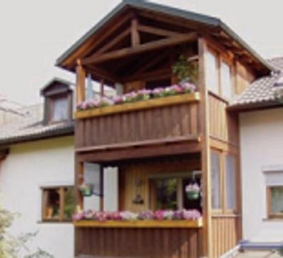 ein Haus mit einem Balkon mit Blumen darauf in der Unterkunft Ferienwohnung Hofer in Altötting