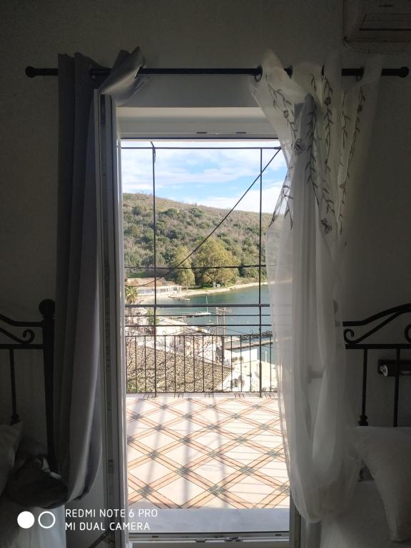 a door to a balcony with a view of the water at Villa Nikos in Ágios Stéfanos