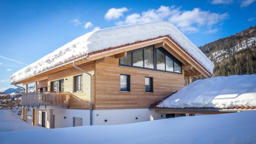 a wooden house with snow on the roof at Villa Wanderlust in Reit im Winkl