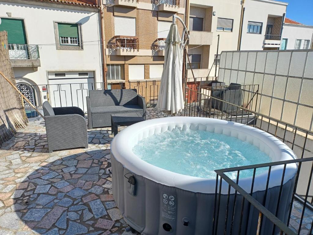 - un bain à remous sur une terrasse avec un bâtiment dans l'établissement Enjoy Oporto Flats, à Porto