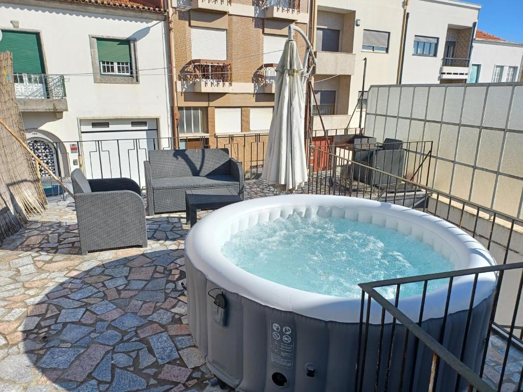 a hot tub on a patio with a building at Enjoy Oporto Flats in Porto
