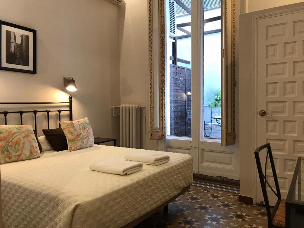 1 dormitorio con 1 cama con 2 toallas en Casa Consell Bailen, Guest House, en Barcelona