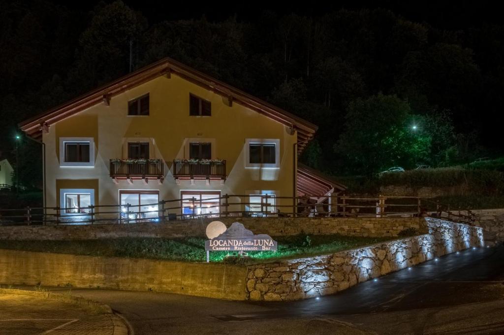 a building with a sign in front of it at night at Locanda della Luna in Ronco Canavese