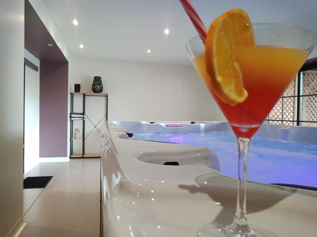 une boisson dans un verre de martini avec une tranche d'orange dans l'établissement L'hacienda, à Tartas