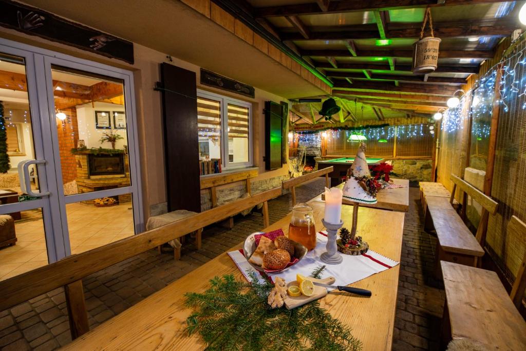 um restaurante com longas mesas de madeira com comida em Bacówka u Winiarskich em Nowy Targ