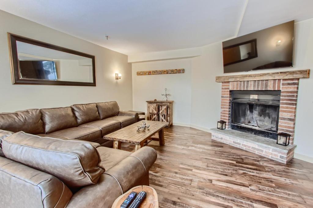 a living room with a couch and a fireplace at Mountain Green, Condos at Killington in Killington