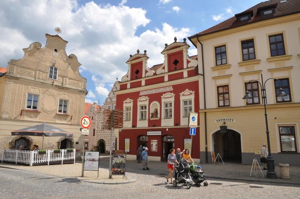 un gruppo di persone che si trovano di fronte agli edifici di Apartmány Tábor a Tábor