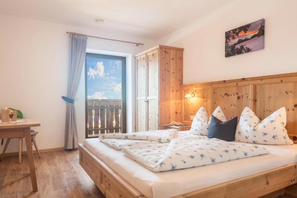 a bedroom with a large bed with a large window at Schildberghof Schlernblick in Siusi