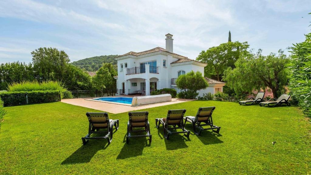 um grupo de cadeiras sentadas num relvado em frente a uma casa em Villa Grazalema 2 - Villa 39 Arcos de la Frontera by Ruralidays em Arcos de la Frontera