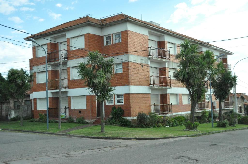 un edificio de apartamentos con palmeras delante en Departamento del Mar en Mar del Plata