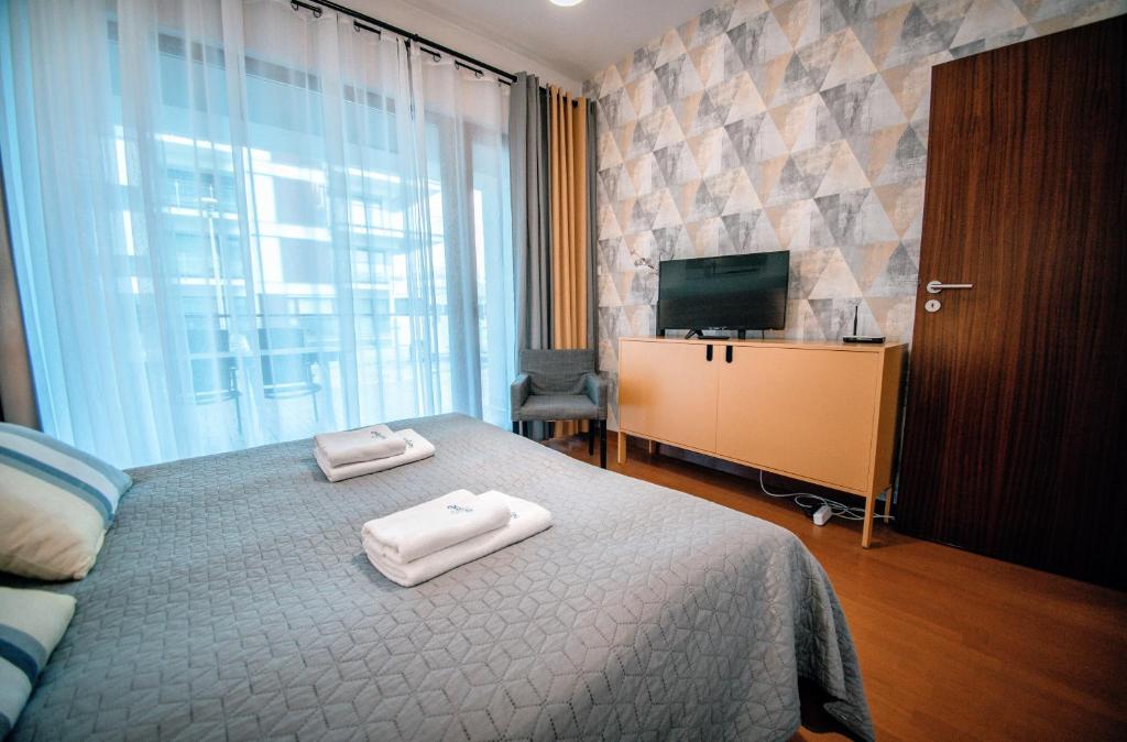 Posteľ alebo postele v izbe v ubytovaní Apartamenty na Wyspie - Baltic Park 3.0.7 - Apartament z 2 sypialniami i 80 m² tarasem