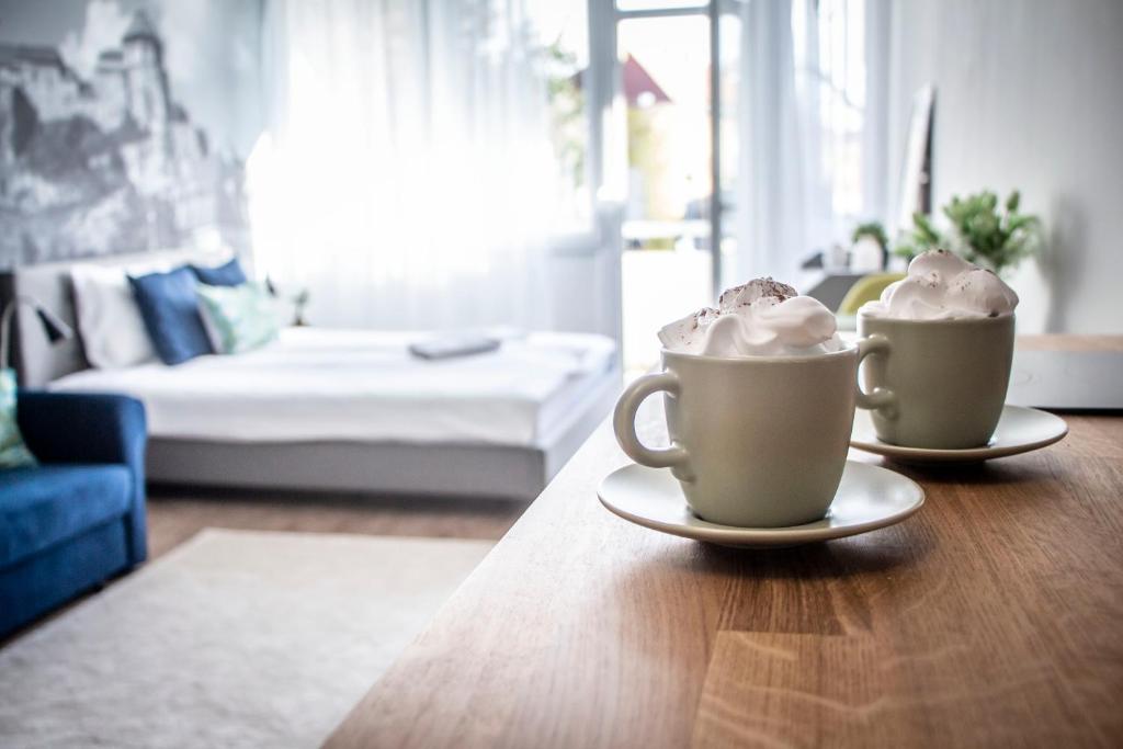 zwei Kaffeetassen auf einem Tisch im Wohnzimmer in der Unterkunft LouLou's Central Apartment with cosy balcony in Esztergom