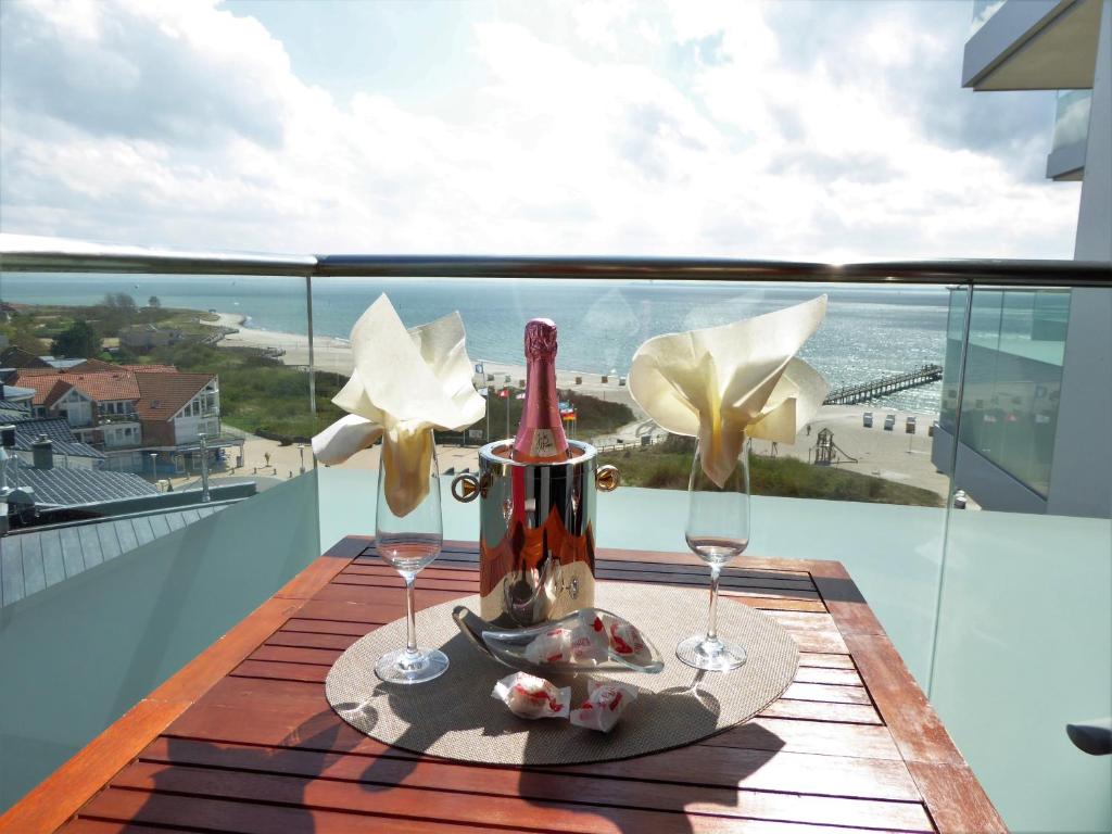stół z 2 kieliszkami do wina na balkonie w obiekcie Appartement Meeresbrise w mieście Pelzerhaken
