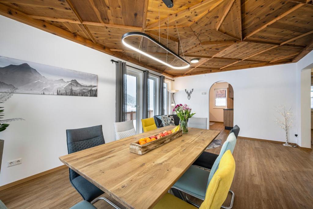翁特陶埃恩的住宿－Ferienwohnung Weiß，一间带木桌和椅子的用餐室