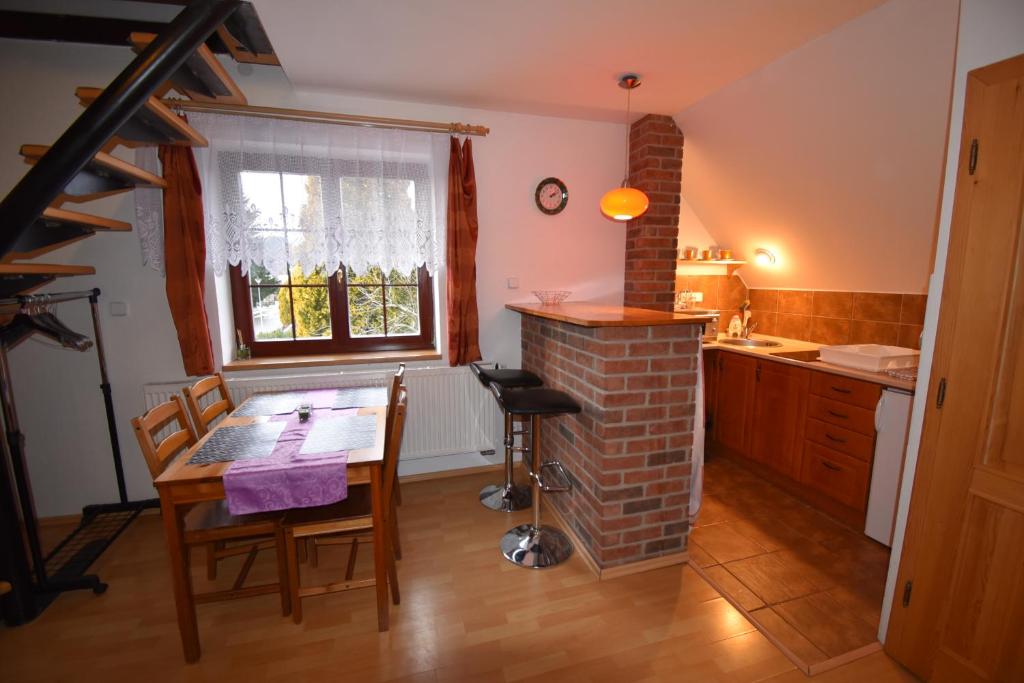 cocina con mesa y chimenea de ladrillo en Apartmány Sněženka en Deštné v Orlických horách