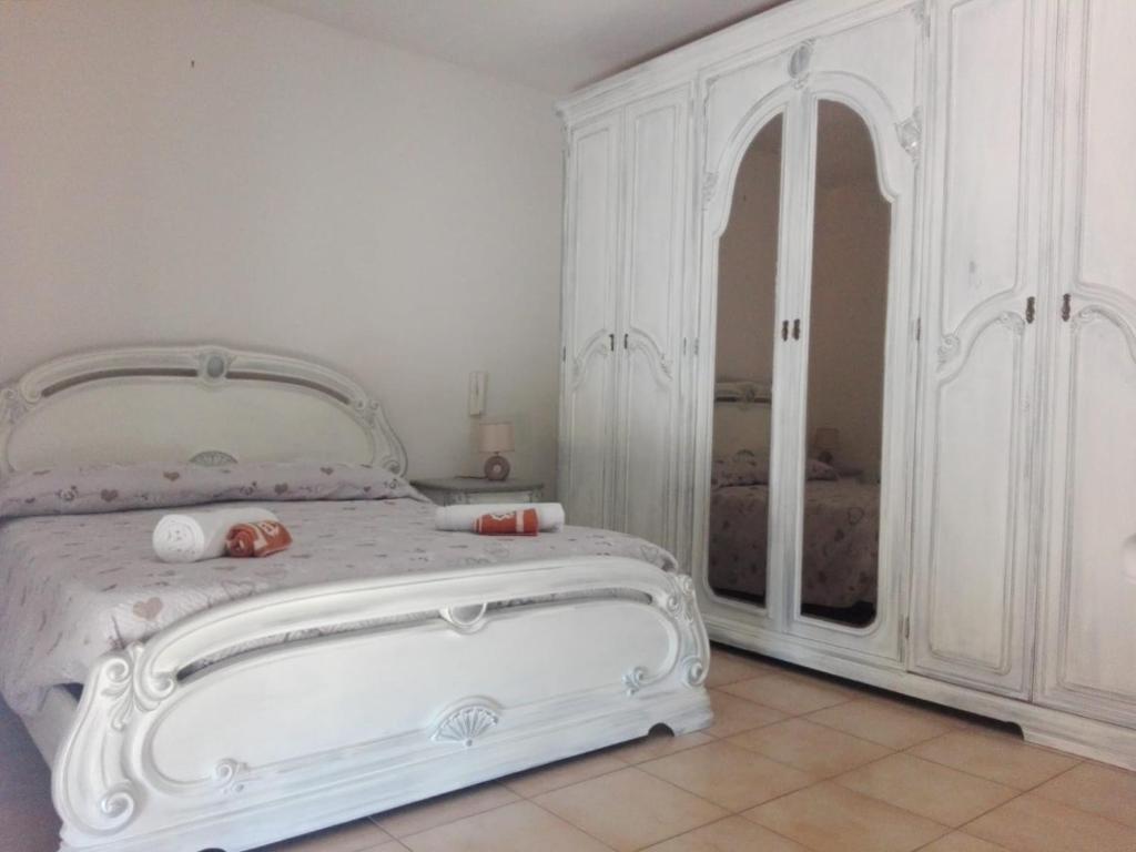 ein Schlafzimmer mit einem weißen Bett und einem weißen Schrank in der Unterkunft Villa Stella in Campobello di Licata