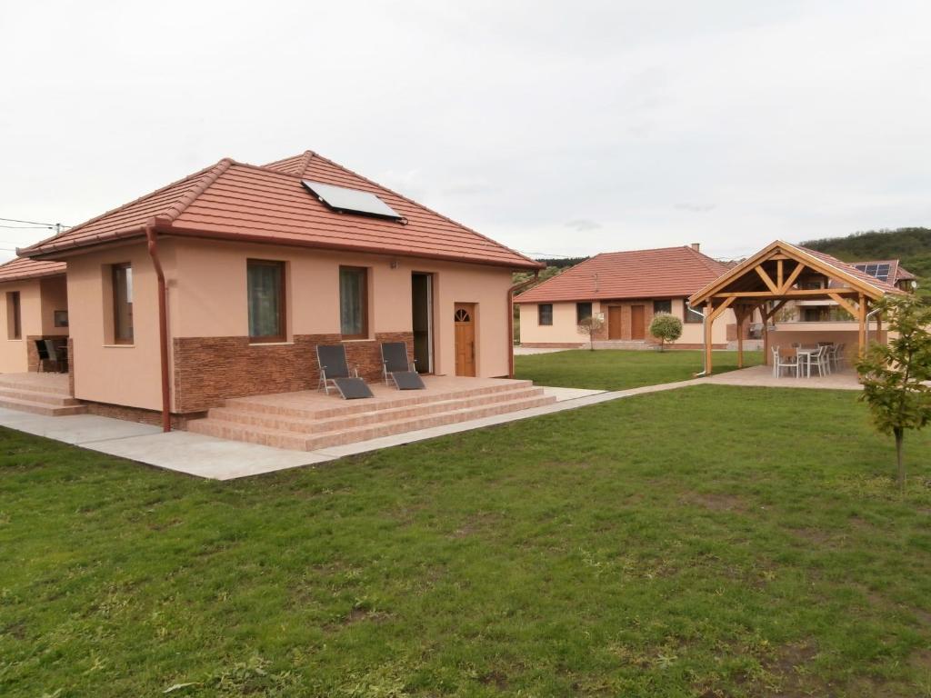Ein Haus mit einer Terrasse und einem Hof in der Unterkunft NATURA Vendégházak in Demjén