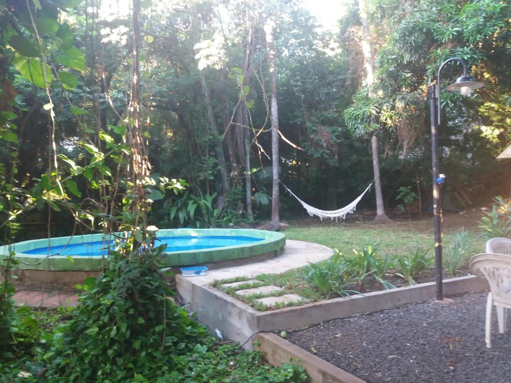 una piscina en un jardín con una hamaca en CasaNatura en Posadas