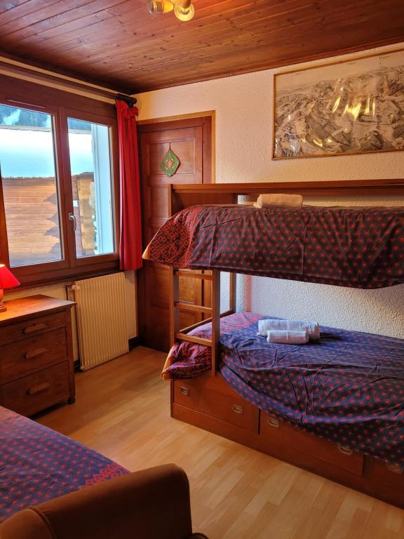 a bedroom with two bunk beds and a window at Chalet LE TRIOLET in Chamonix