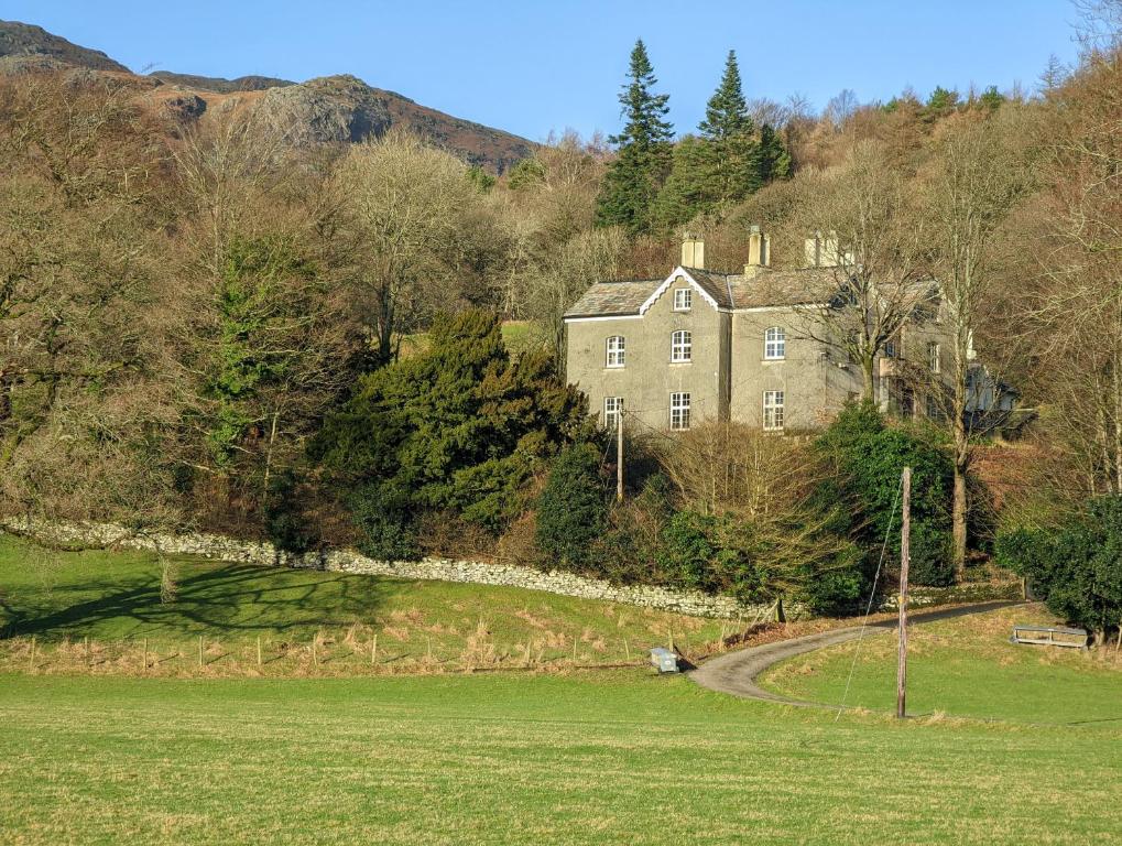 an old house on a hill with a grass field at Thwaite House in Coniston