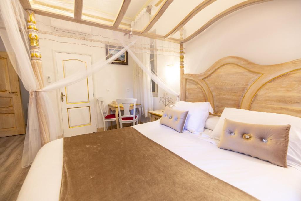um quarto com uma grande cama branca com almofadas azuis em Chambre a Baldaquin Maison de L'Église Du couvent em Narbona