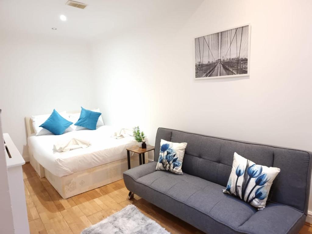 - un salon avec un canapé et un lit dans l'établissement F1-Basement Studio Fits 3 Near Paddington, à Londres