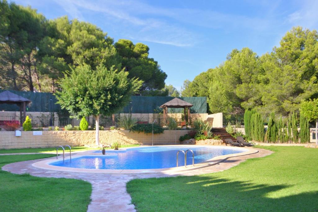 a swimming pool in a yard with a gazebo at Bungalow Azalea - PlusHolidays in Calpe