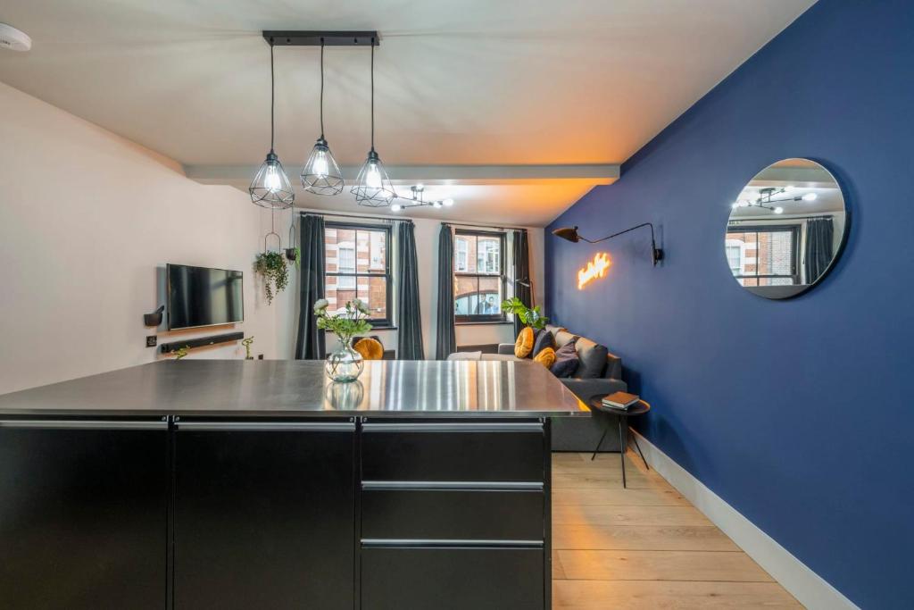 a kitchen with a counter top and a blue wall at The Good Vibes Parlour - Covent Garden - by Frankie Says in London